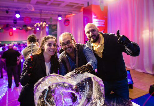 A group proudly showcases their completed ice sculpture during a Team building Ice Sculpting event, celebrating their teamwork and creativity.