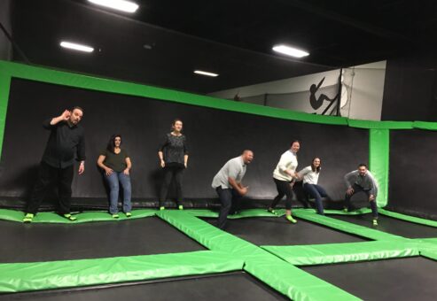 Team members bouncing with joy on trampolines during a Mystery Bus team building event, adding fun and energy to their day of surprises and adventure.