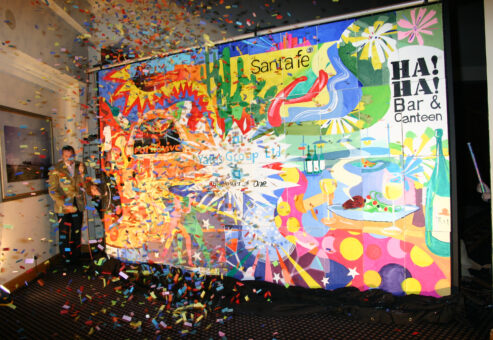 A vibrant mural is unveiled with a burst of confetti during The Big Picture team building event, celebrating collaboration and creativity.