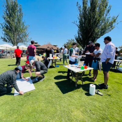 Teams collaborate outdoors on individual canvases during The Big Picture team building event, working together to create a collective mural that promotes communication and teamwork. thumbnail