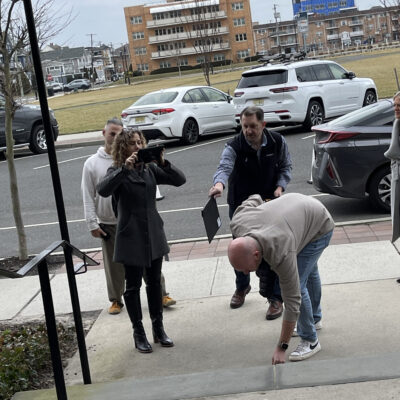 Team members conducting a hands-on outdoor activity, with one person recording one of her team members acting on the Corporate Film Festival team building challenge. thumbnail