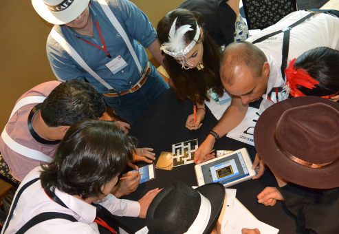 A team collaborates in the Escape the Mob event, solving puzzles and decoding clues to piece together an alibi and solve the mystery.