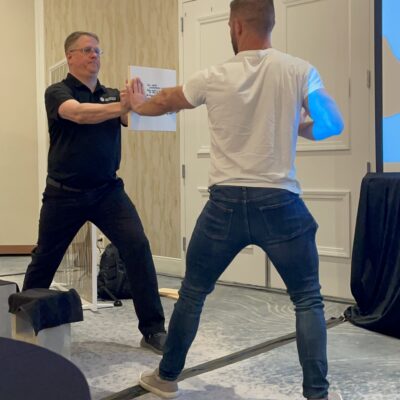 A participant prepares to break a board held by the facilitator during a team building activity designed to help overcome personal barriers. thumbnail