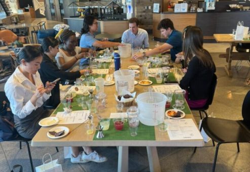 Team gathered around a table during a mixology class, crafting cocktails and enjoying the experience together. The interactive event fosters collaboration, creativity, and camaraderie in a relaxed setting.