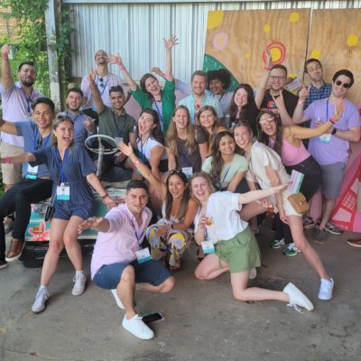 Group photo of a team full of energy and excitement during a Mystery Bus team building event, posing together for a fun and memorable moment. thumbnail