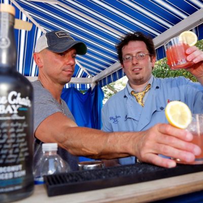 Two team members toasting with freshly made cocktails at a mixology event. The hands-on class promotes teamwork and creativity as participants craft and enjoy their own drinks together. thumbnail