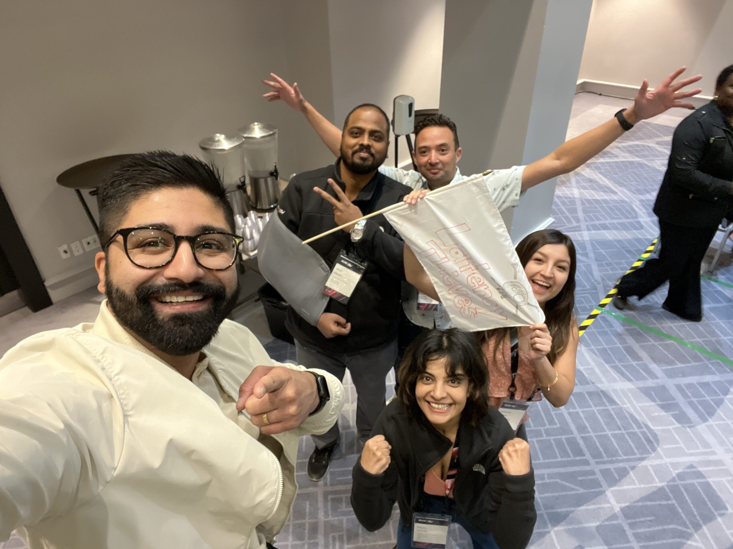 A team excitedly poses with their drone creation after completing a challenge during the Game of Drones team building event.