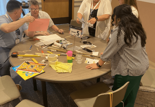 Team members work together on planning their bridge design during the Bridging the Divide team building activity.