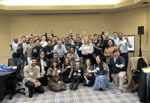 Participants pose together in celebration after completing their STEM Speedway race car projects in a team building event.