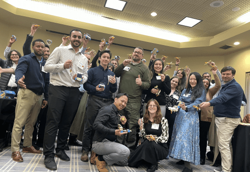 Participants proudly holding their STEM race car creations after a successful team building session at STEM Speedway.